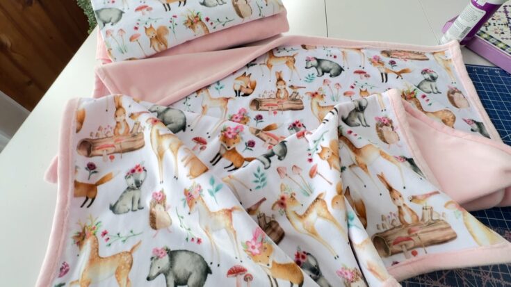 cuddle minky baby blanket with pastel forest animals on one side and pink on the other